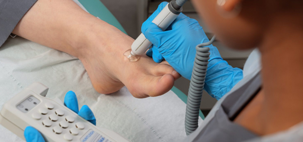 Podiatrist using doppler on foot.